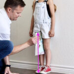 Child getting her inseams measured for a bike by using the book method