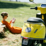 A rider on a 125cc motorcycle navigating city traffic