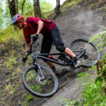 A rider on a BMW adventure bike navigates a rocky trail, showcasing its rugged capabilities