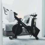 RE:GEN bike in a bedroom on a gray carpet with a white towel over the handlebars