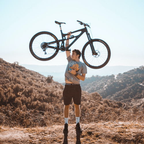Man celebrates after repairing broken spoke, lifting bike