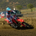 Guy rides Honda dirt bike during a race