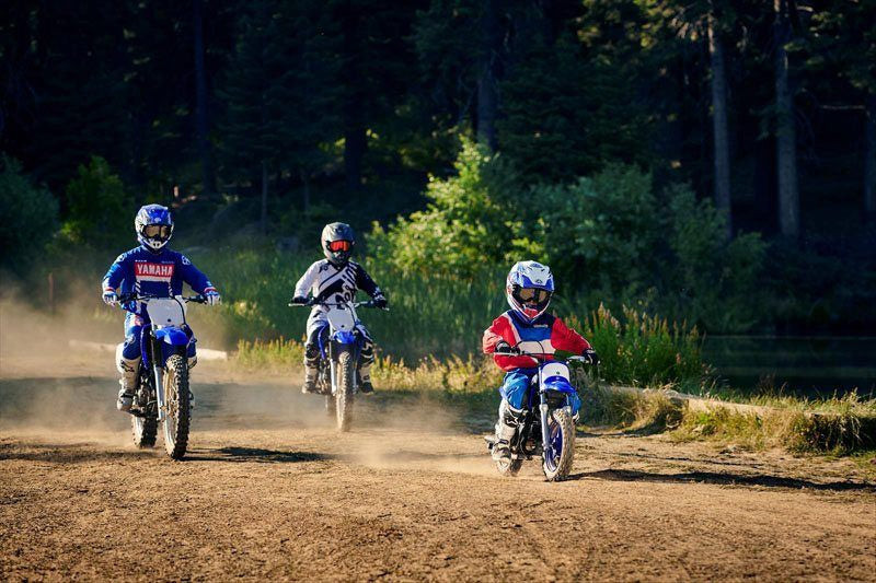 A group of dirt bikes of varying sizes riding on a dirt road, illustrating different bike sizes for different ages