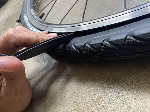 Using tire levers to separate the tire from the wheel