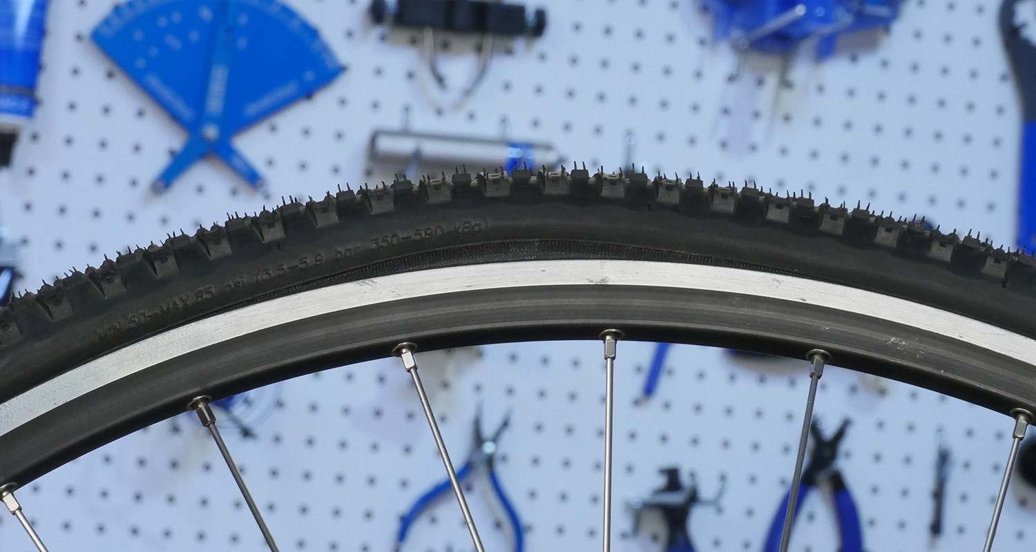 This bead seat line is bulging upward from improper tire seating. Deflate immediately and reseat tire.