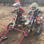 Two peewee racers lined up at a race start, showcasing the excitement of youth motocross